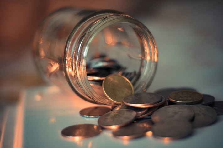 An overturned jar full of coins.